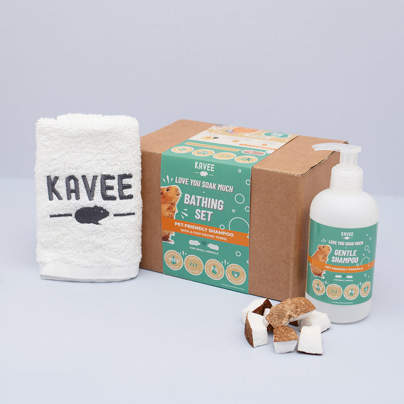 Kavee Cage Bathing set for guinea pigs. Lifestyle shot of shampoo, towel and box on grey background