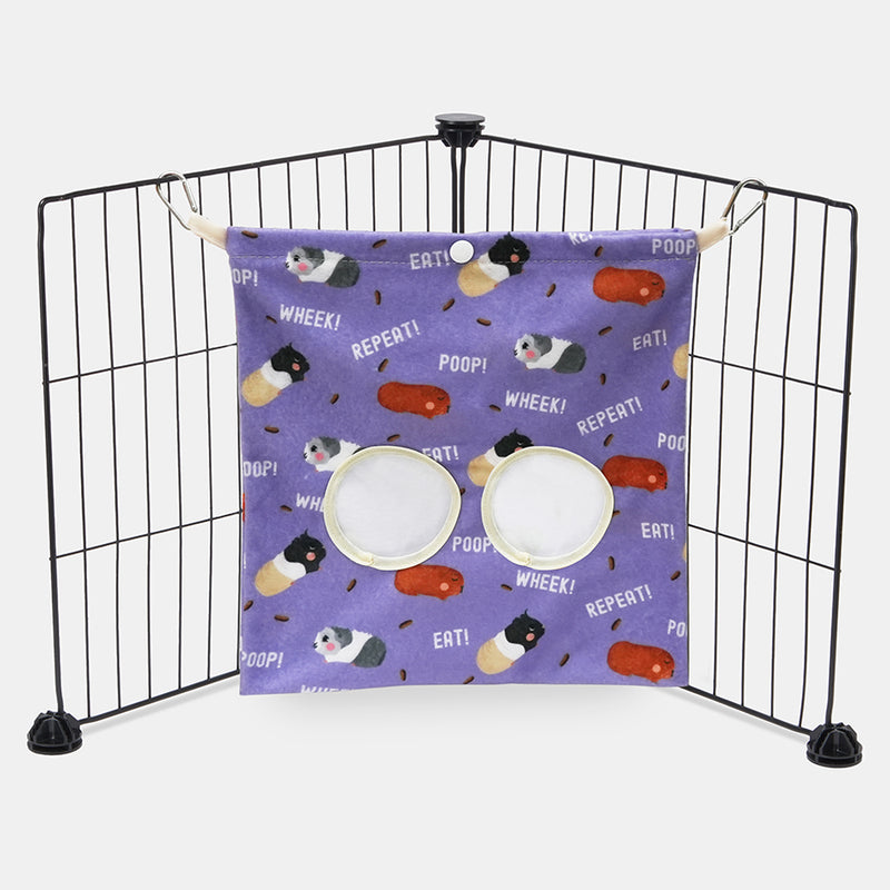 Purple haybag with poop design by brand Kavee hanging from two black metal grids on grey background