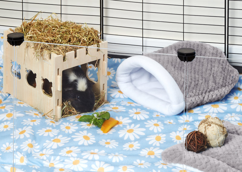 grey fleece sleep sack next to guinea pig hiding in wooden castle tunnel sitting on daisy print fleece liner in c and c cage